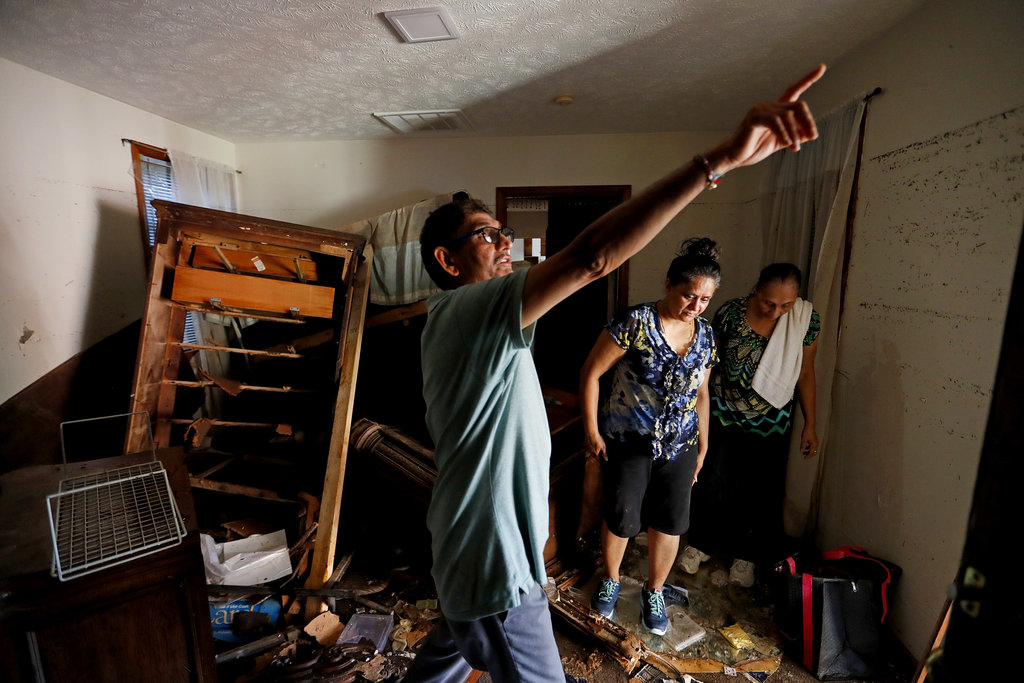 Smita Depani (centre) stands in the apartment she lived in while surveying the damage with her brother-in-law Jayanti Depani (left) and sister-in-law Puspa Manvar in the motel they own, which was destroyed in the flooding.