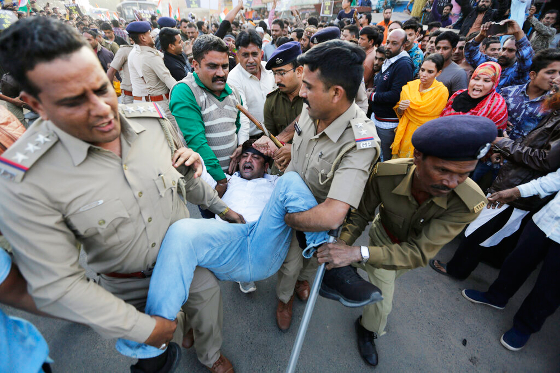 Police detain a man during a protest against the Citizenship Amendment Act and the National Register of Citizens in Ahmadabad.