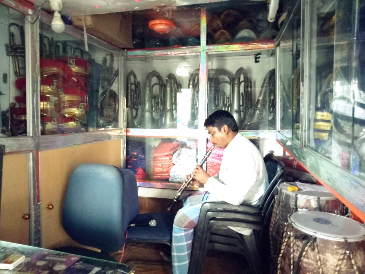 Mohammed Hassan plays a clarinet in his band shop at Bistupur on Tuesday. 