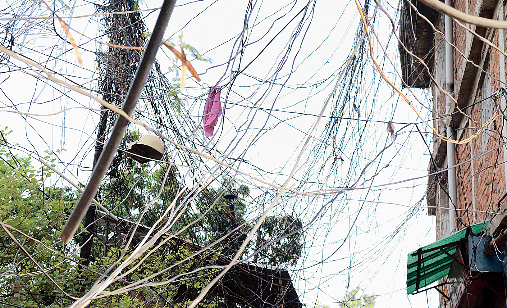 Thousands of overhead wires (left) dangle from Roshpa Tower on Main Road in Ranchi on Monday. 
