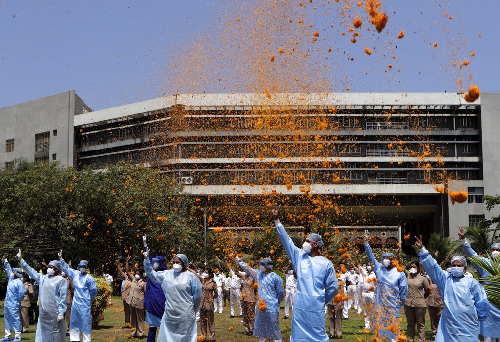 An Indian Air Force helicopter showers flower petals on the staff of INS Ashwini hospital in Mumbai, Sunday, May 3, 2020.