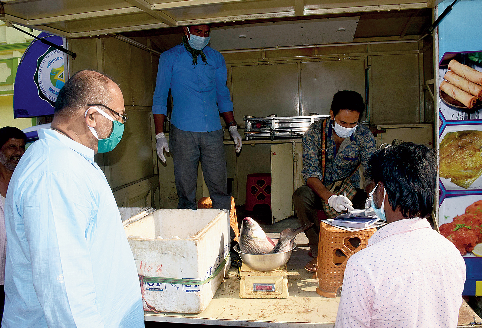 Minister Chandranath Sinha monitors the sale of fish from a government van in Bolpur on Saturday. 