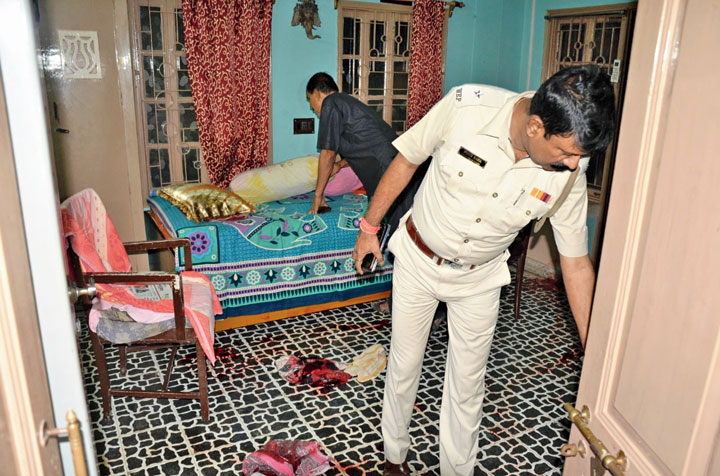 Cops check the house of the couple after the attack on Monday