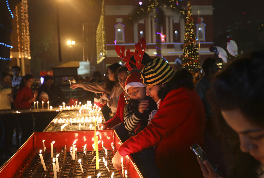 Indians light candles outside the Sacred Heart Cathedral on Christmas eve in New Delhi, India, Tuesday, Dec. 24, 2019.