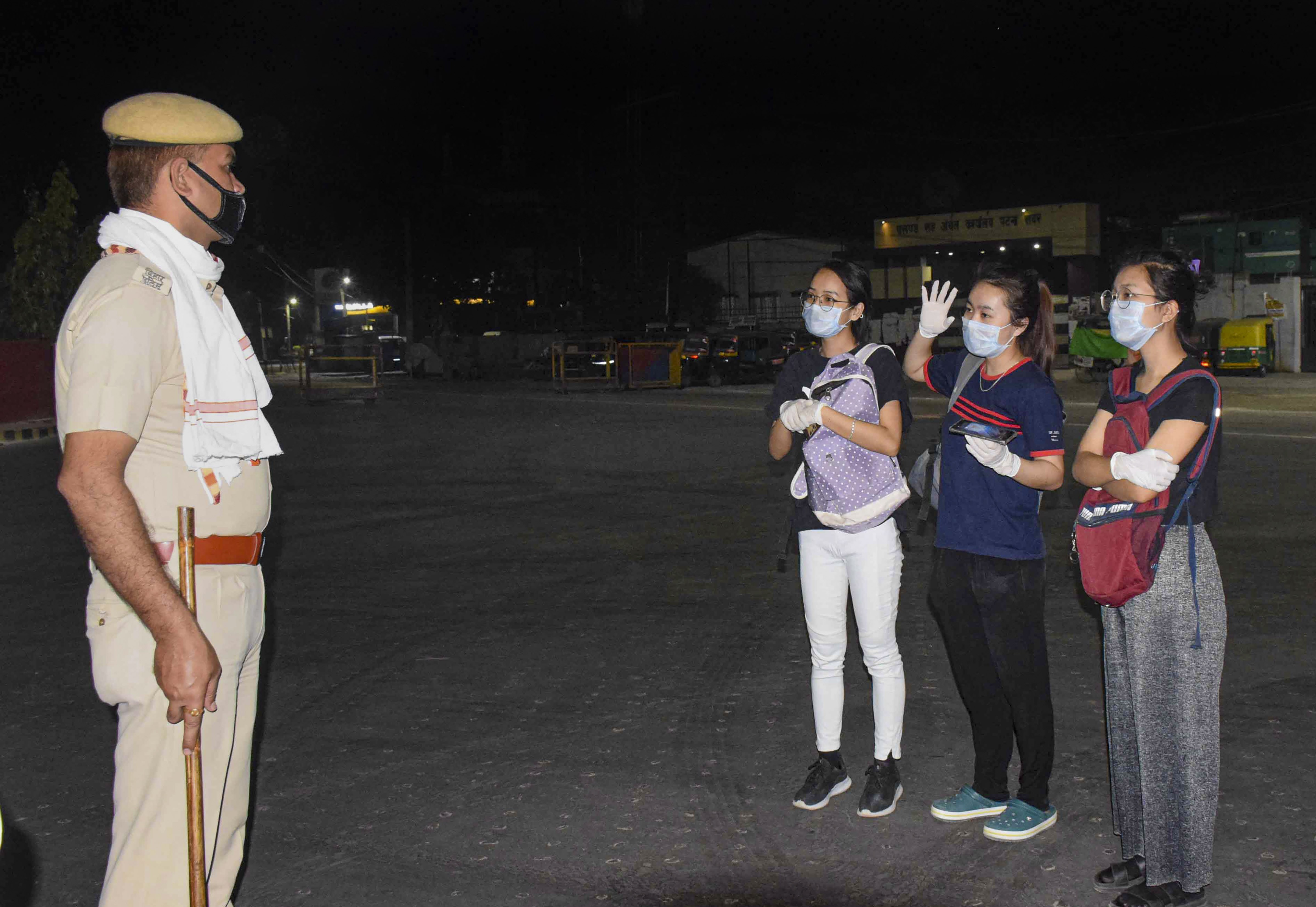 A policeman enquires from tourists about their travel history during a nationwide lockdown in the wake of coronavirus outbreak, in Patna, Friday, April 10, 2020.