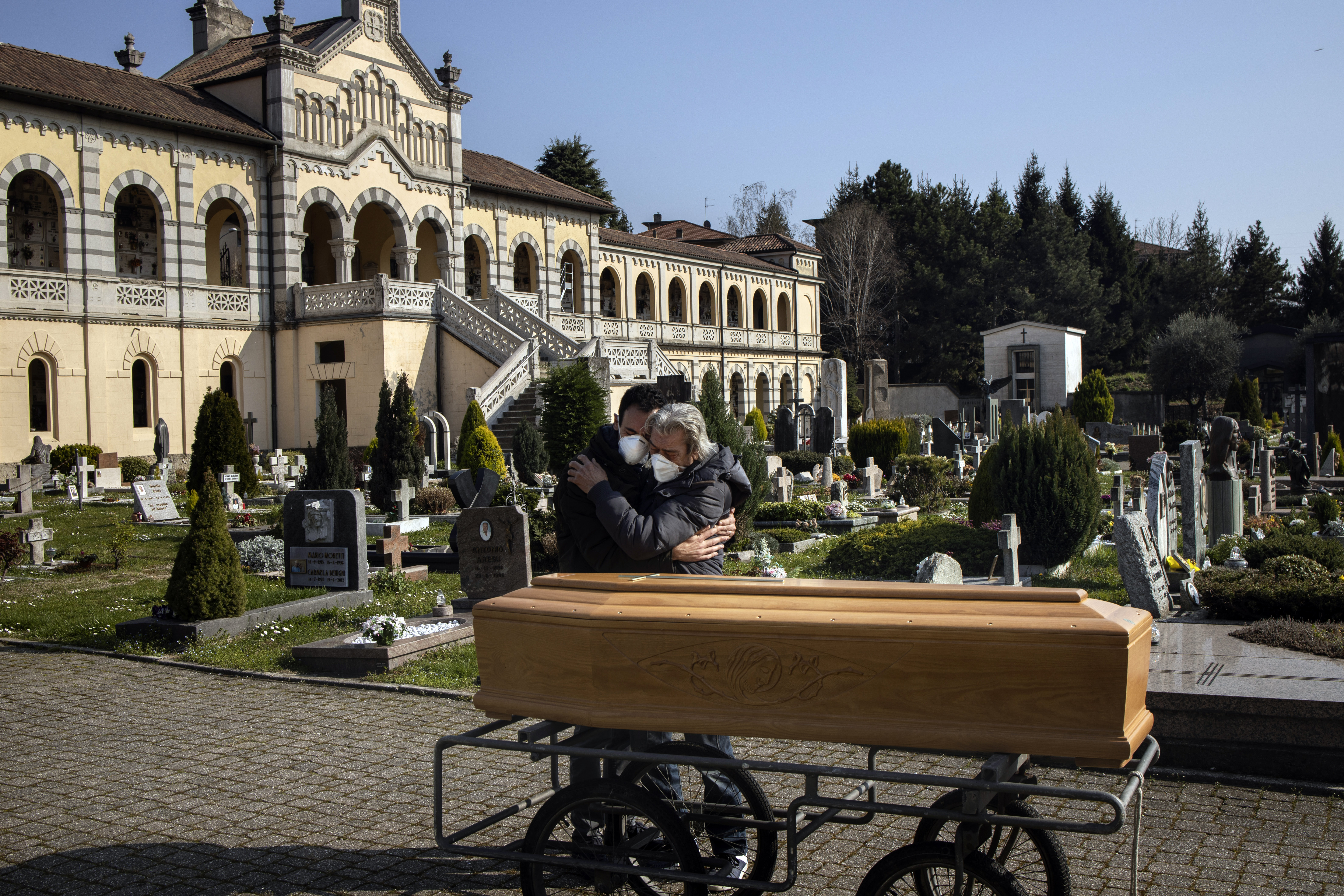 The husband and son of Teresina Gregis mourn after her funeral in Alzano Lombardo, Italy, March 21, 2020. Gregis, who had pre-existing heart and respiratory problems, died at home without being tested for the coronavirus.