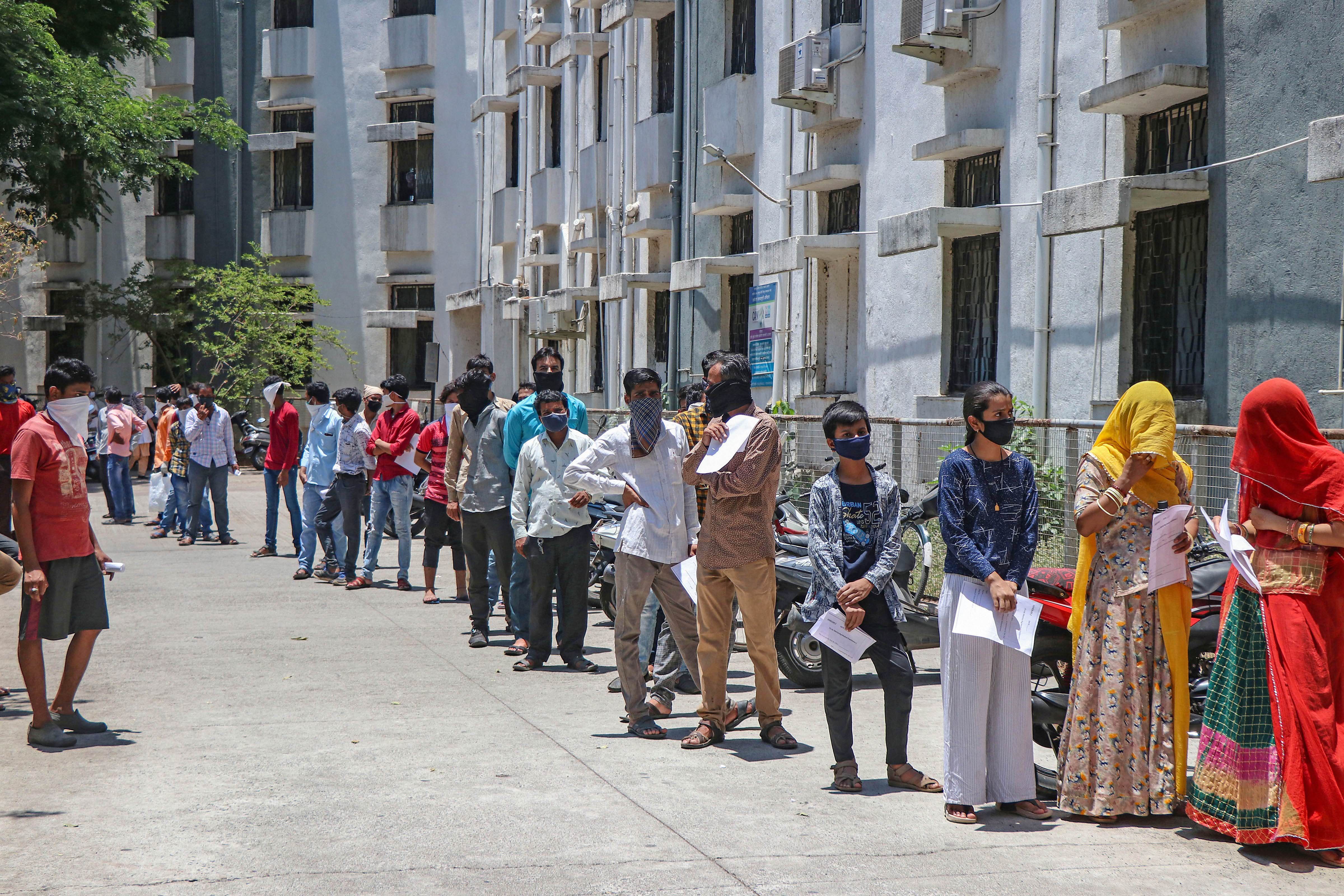 Stranded migrant workers from different states queue up outside the District Hospital to collect health certificates as part of the formalities to leave for their native places, amid Covid-19 lockdown in Pune, Maharashtra, Monday, May 4, 2020.
