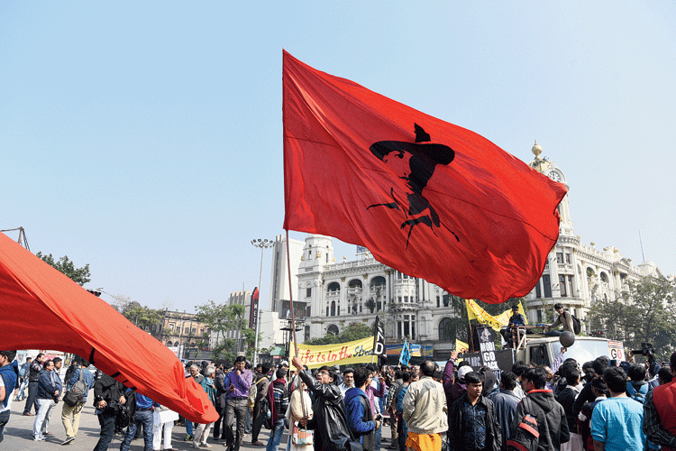 A protester waves a red flag with a picture of Bhagat Singh on it at the Dorina crossing