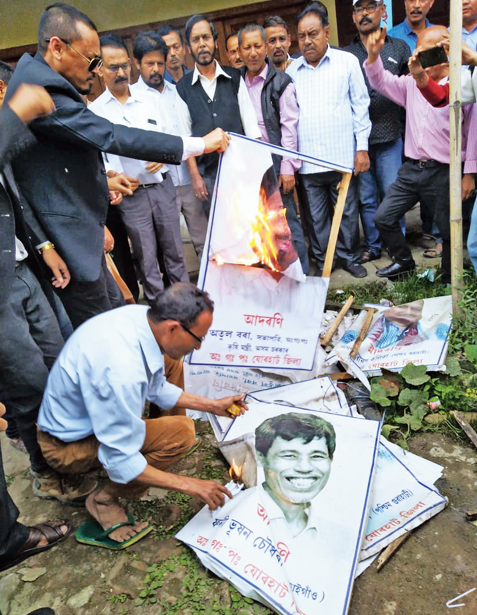 Party workers burn posters in Jorhat on Friday. 

