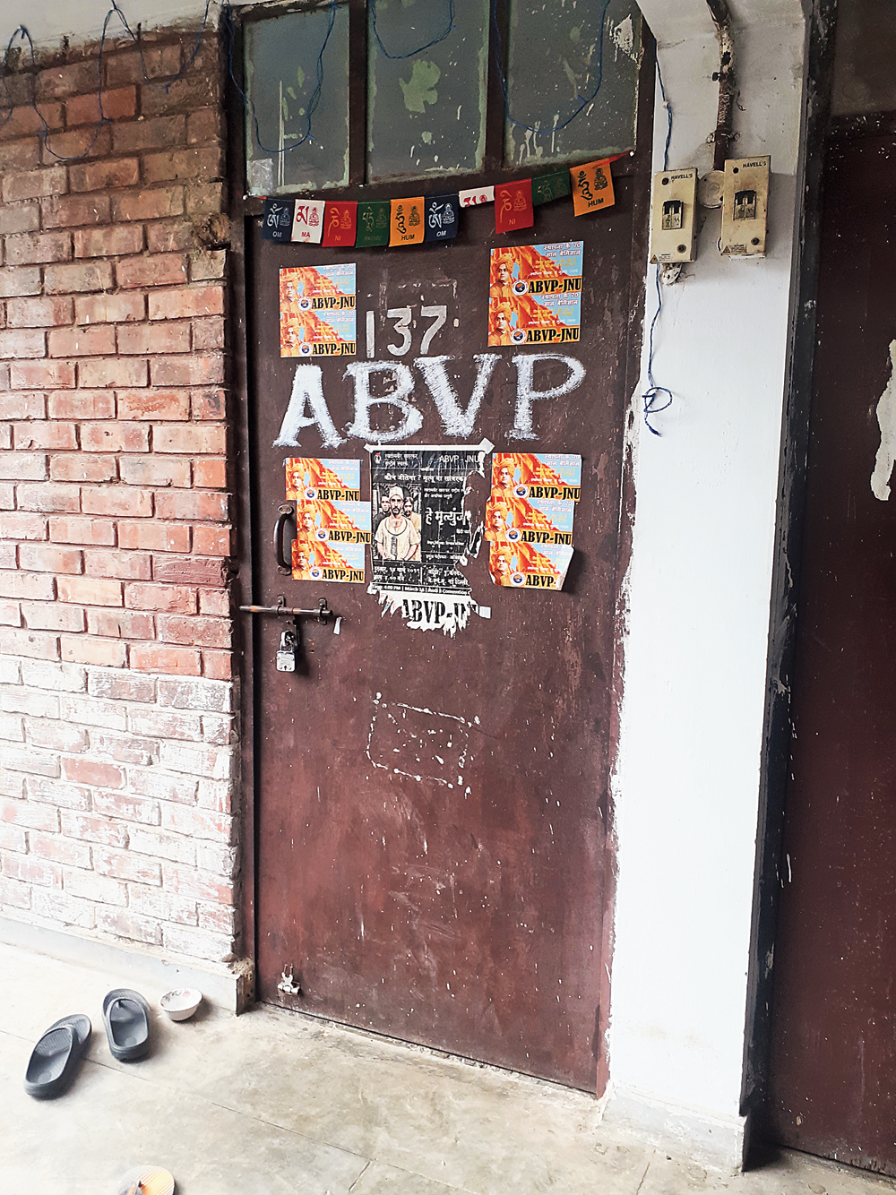 A hostel room with “ABVP” stickers on the door