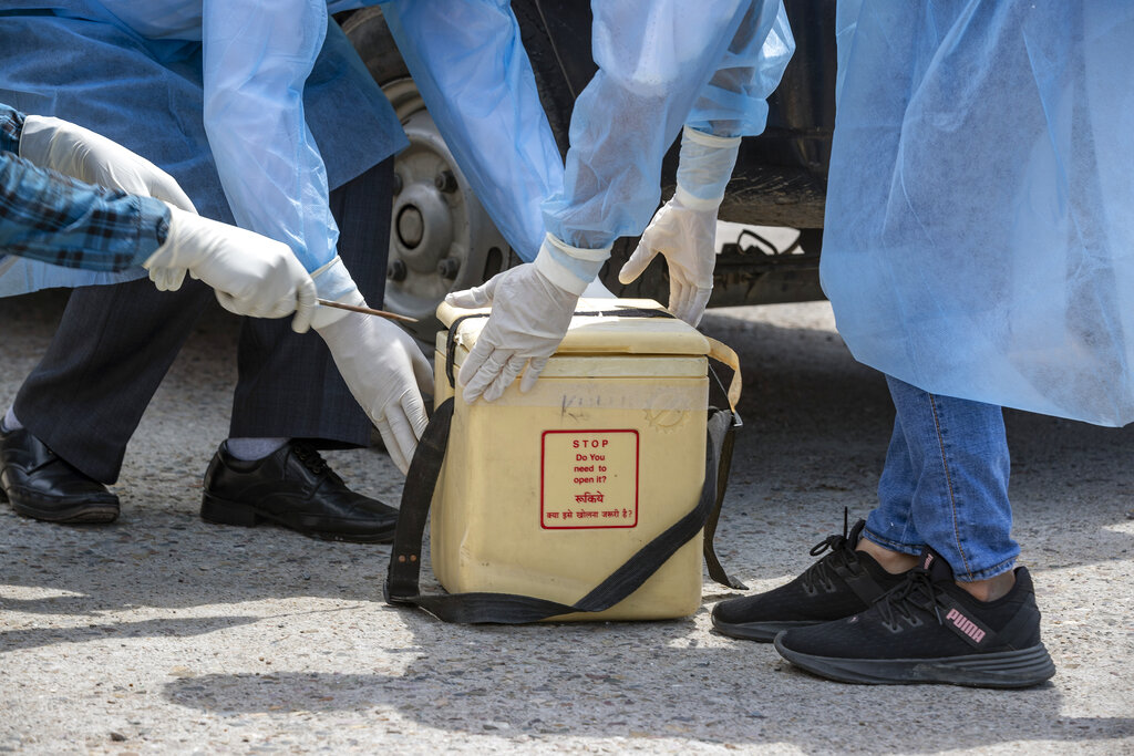 Doctors open a cooler which will transport samples collected in Dharmsala to be tested for the coronavirus, in Dharmsala, on Saturday, May 9, 2020.