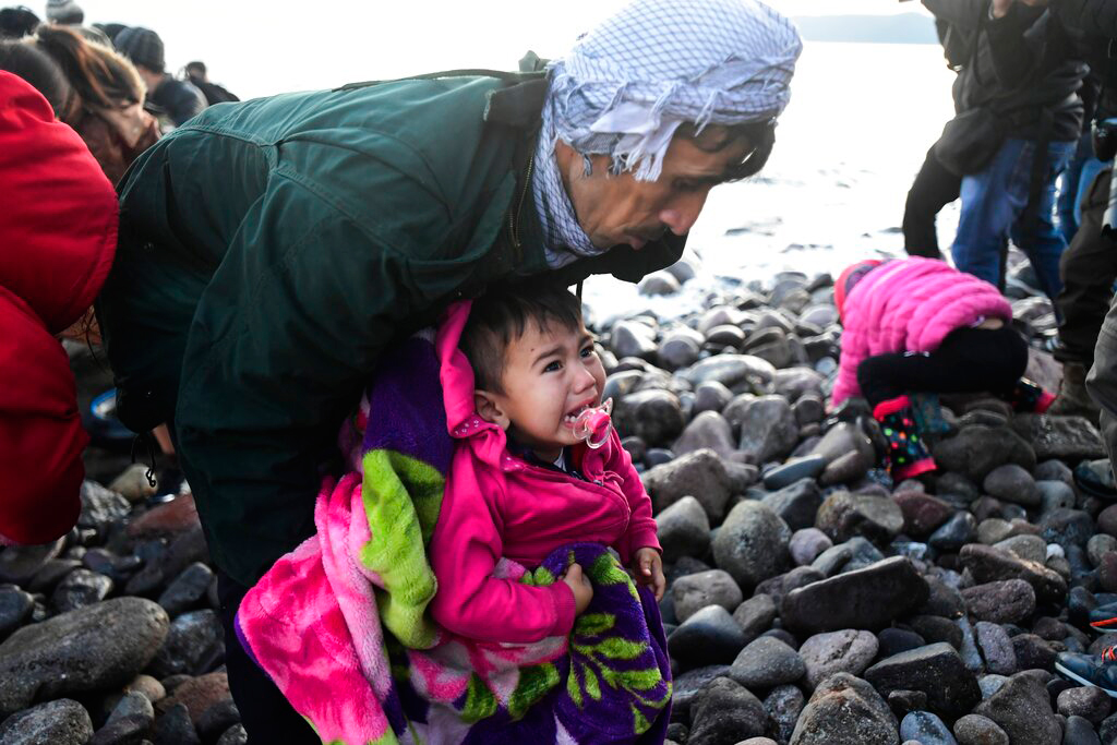 A child cries as migrants arrive on the Greek island of Lesbos after crossing on a dinghy the Aegean sea from Turkey on March 2