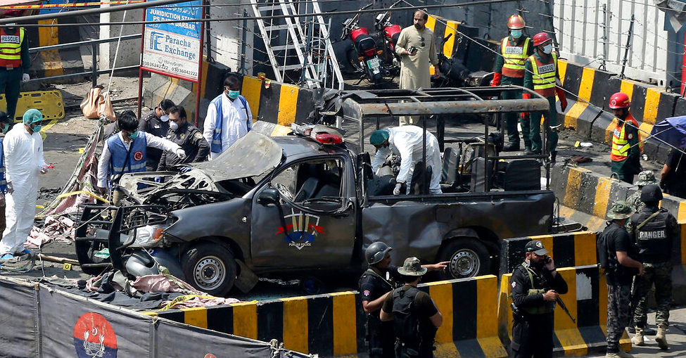 Pakistani security personnel surround a damaged police van in Lahore, Pakistan, Wednesday, May 8, 2019. 