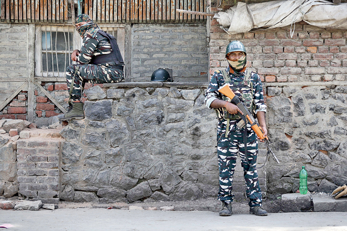 Soldiers stand guard outside the main telephone exchange building in Srinagar on Thursday