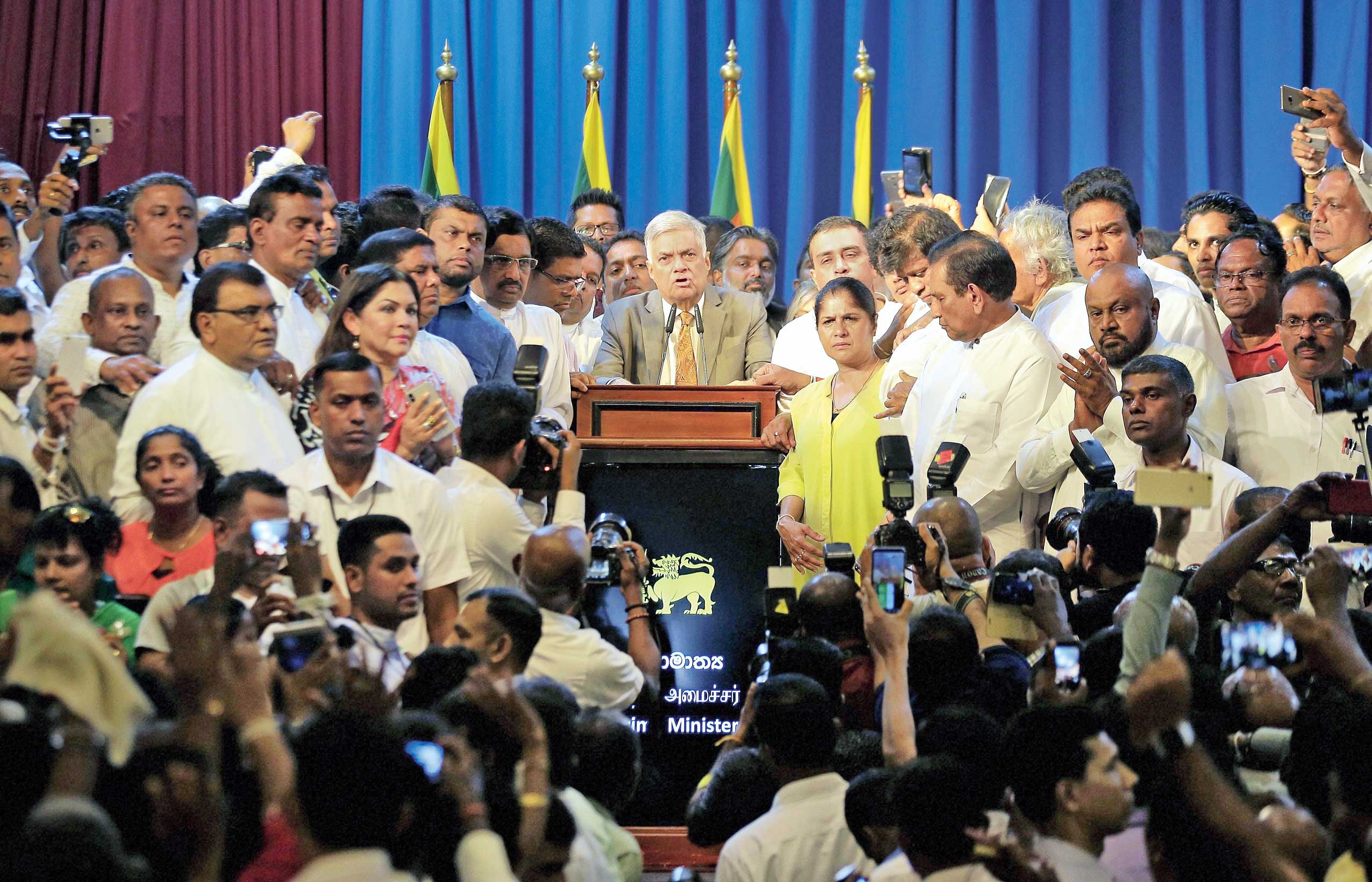 Sri Lanka’s reinstated Prime Minister Ranil Wickeremesinghe (centre) speaks after assuming office in Colombo on Sunday. 
