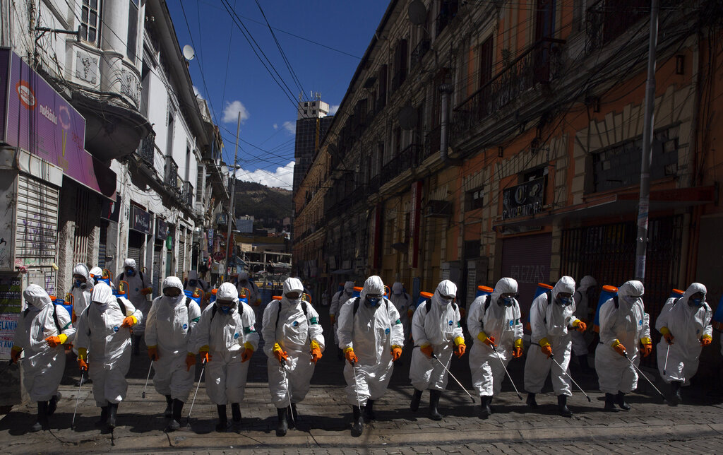 City workers fumigate a street to help contain the spread of the new coronavirus in La Paz, Bolivia, Thursday, April 2, 2020.