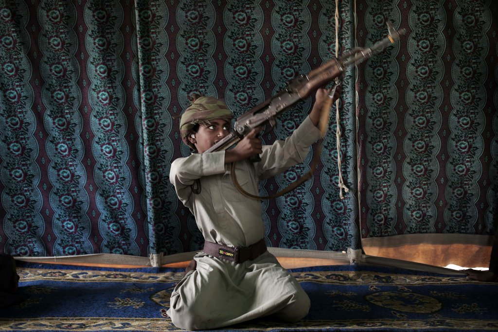 Kahlan, a 12-year-old former child soldier, demonstrates how to use a weapon, at a camp for displaced persons where he took shelter with his family, in Marib, Yemen.
