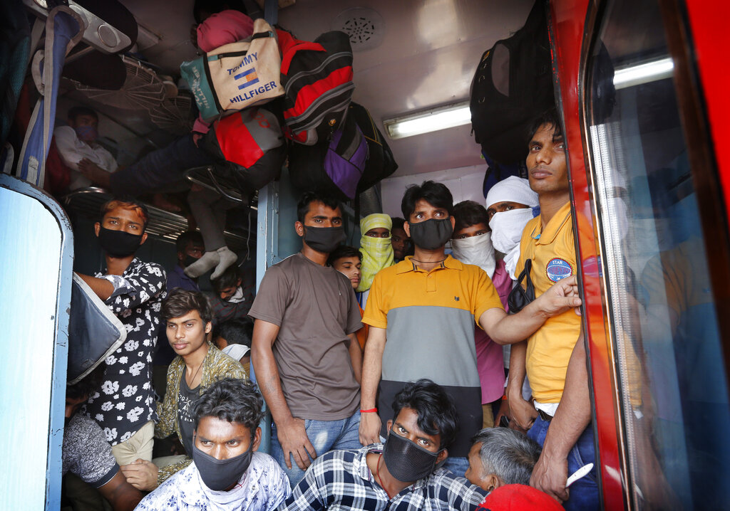 Daily wage laborers, returning from Mumbai travel to their villages amid Coronavirus concerns in a crowded train coach in Prayagraj, on Sunday, March 22, 2020.
