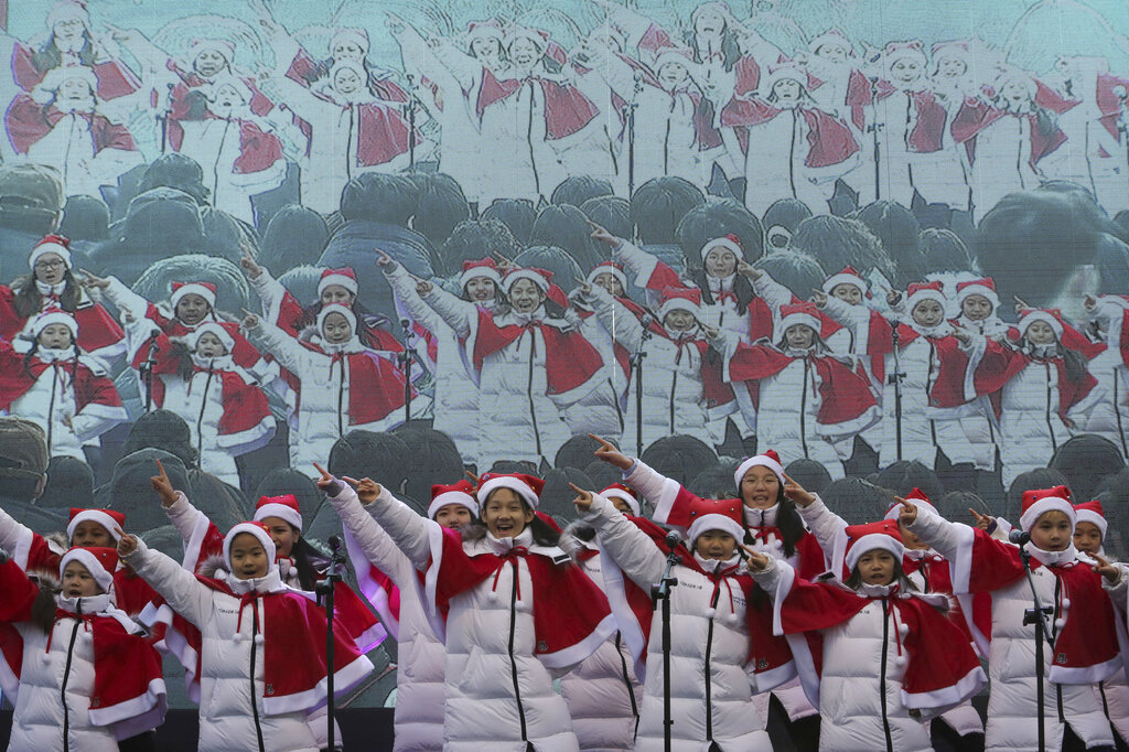 Children sing carols during a Christmas charity event as they gather to deliver gifts for the poor in Seoul, South Korea, Tuesday, Dec. 24, 2019.
