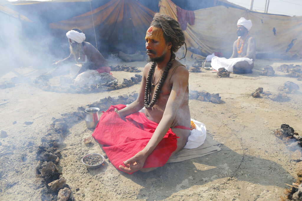Hindu holy men burn dried cow dung cakes as they perform a ritual at the Sangam, the confluence of rivers Ganges and Yamuna, on Basant Panchami day at the annual traditional fair of Magh Mela Prayagraj