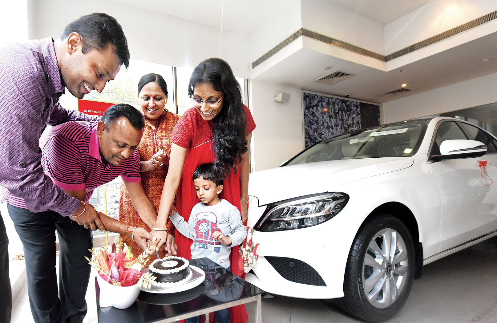 Vijay Kumar Agarwal and his family cut a cake after buying a Mercedes-Benz C Class.