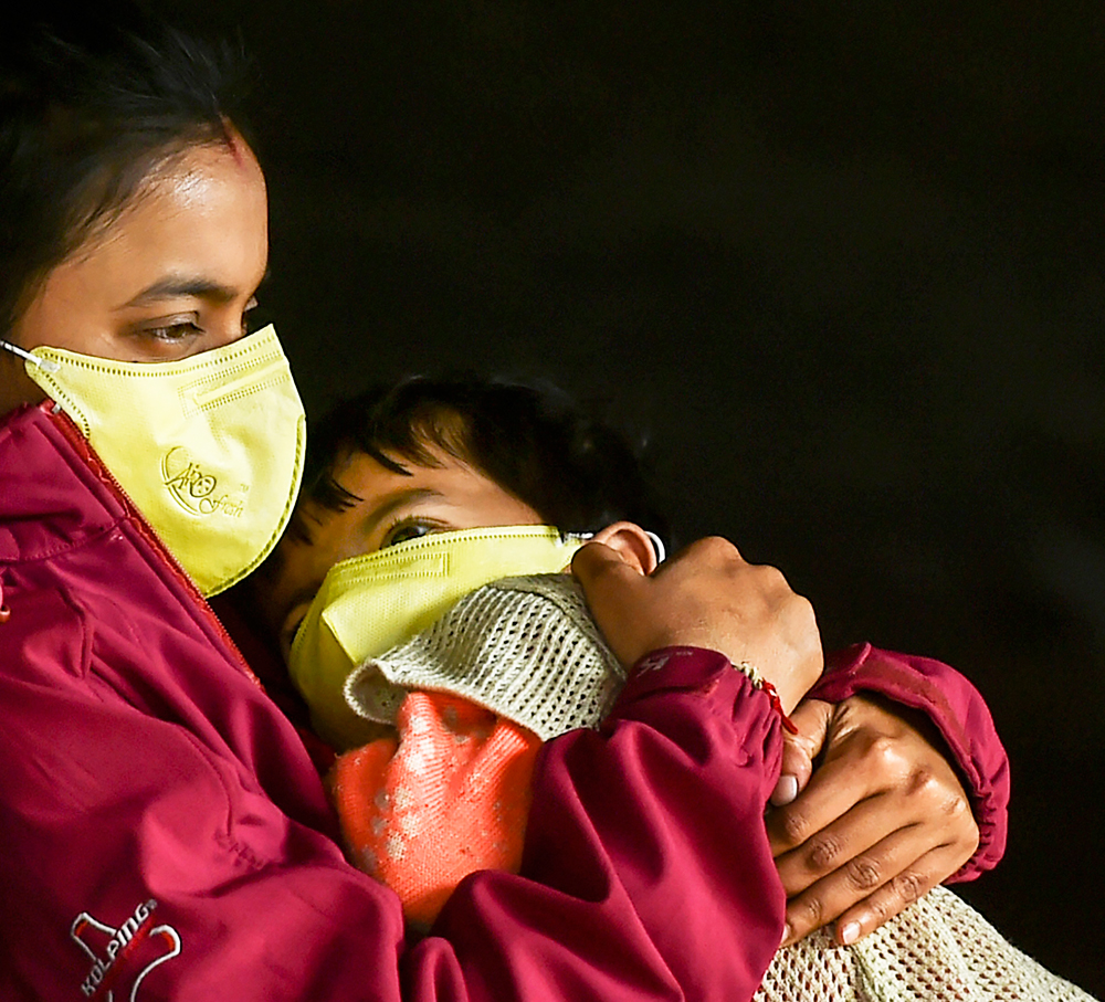 Passengers wear protective face masks in wake of novel coronavirus pandemic at New Delhi Railway Station, Sunday, March 15, 2020. 