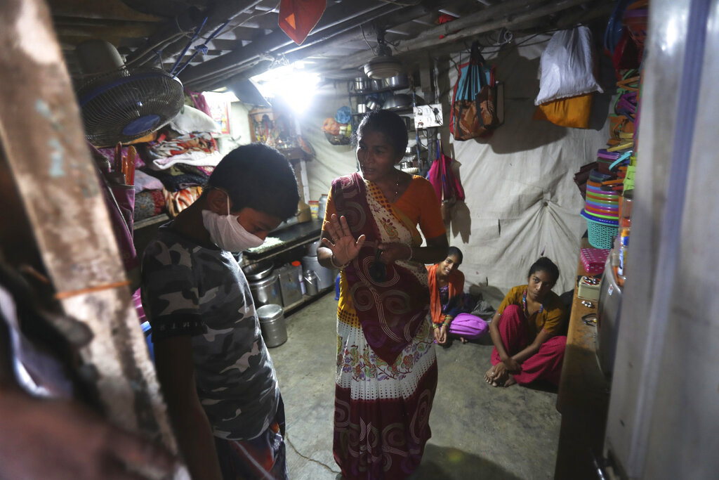 Mina Ramesh Jakhawadiya, center, scolds her son Ritik Ramesh, left, not to go out and play because of coronavirus and be in the house in Mumbai, India. Jakhawadiya makes a living selling cheap plastic goods with her husband on the streets of Mumbai. For her, the order means 21 days in a 6-by-9 foot room with five people, no work, a couple days of food and very less cash. As governments around the world debate ways to slow the spread of coronavirus, India has launched one of the most draconian social experiments in human history, locking down its entire population, including hundreds of millions of people who struggle to survive on a few dollars a day.