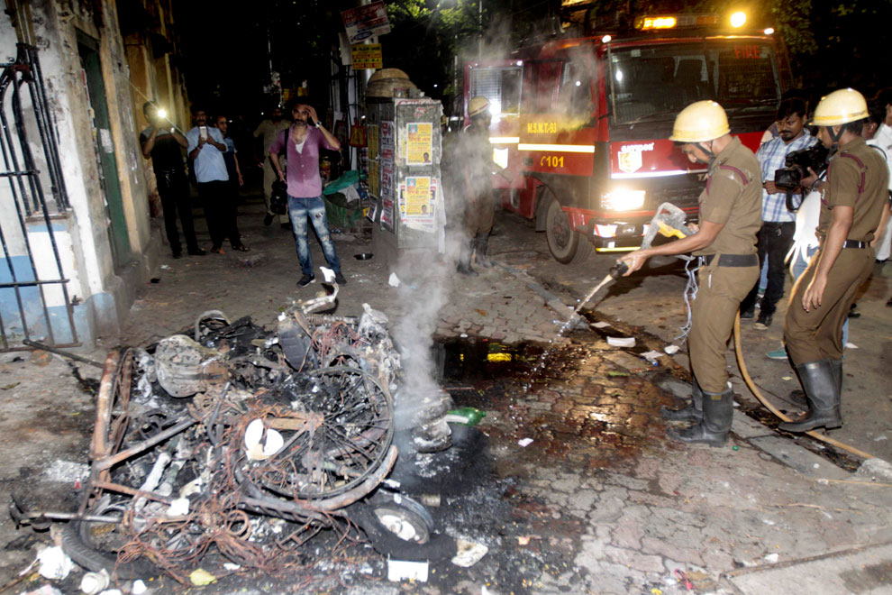 Firemen douse the fire after two-wheelers were set on fire during clashes between Bharatiya Janata Party workers and TMC workers outside Calcutta University in Kolkata on Tuesday, May 14, 2019.