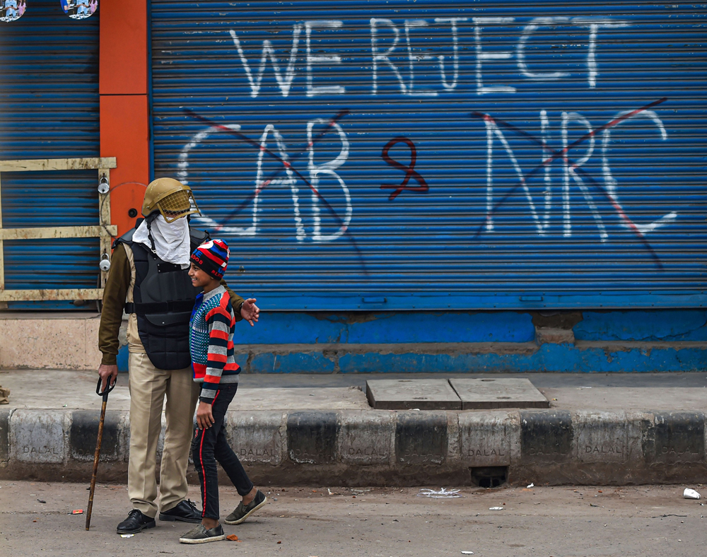 A policeman talks to a boy at Seelampur in New Delhi on Tuesday 
