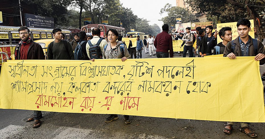 Protesters walk in a rally with a banner that reads in Bengali: “Not Syama Prasad, a traitor in the freedom struggle, a British bootlicker, but Kolkata Port Trust should be named after Rammohun Roy”.
