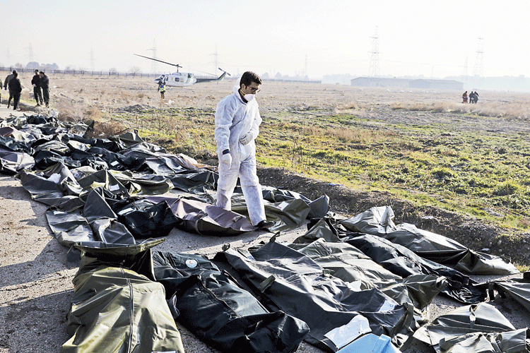 A forensic investigator walks among body bags at the site of the Ukrainian airliner crash in Tehran on Wednesday. 
