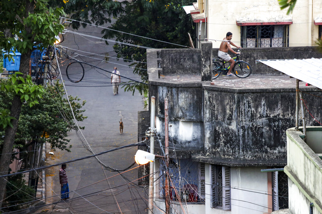 A man cycles on a rooftop during a lockdown to curb the spread of the coronavirus, in Calcutta, Thursday, May 14, 2020.