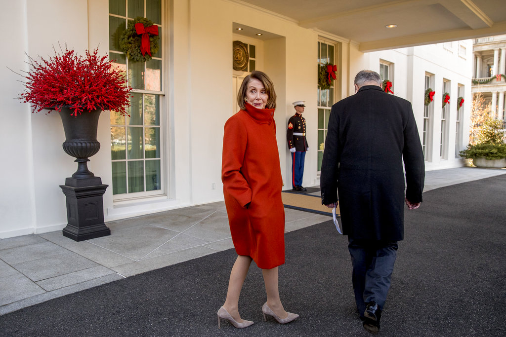 Nancy Pelosi speaks to a reporter as she and Senate Minority Leader Chuck Schumer walk back into the West Wing on Tuesday.