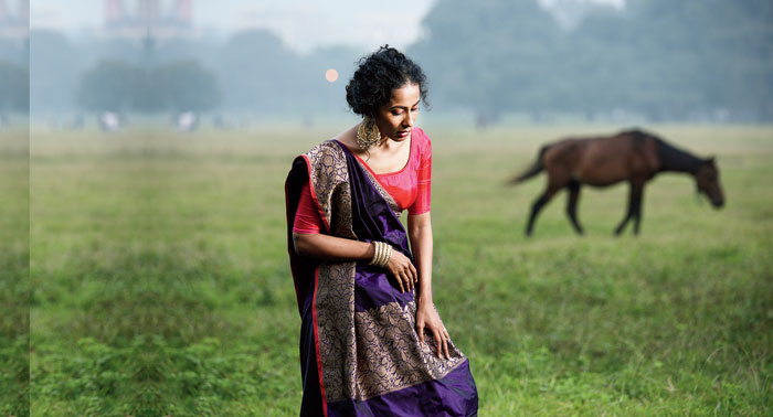 Ushoshi is all mystique-pretty in this dark purple Benarasi with a minimalistic design and a simple thin bright pink border. The broader part of the border and the pallu has brocade woven with golden zari. The silk Benarasi is paired with a simple pink blouse that ups the minimal feel. A pair of chaandbalis accessorise the look. “The look embodies understated elegance. It is perfect for those who like to value traditional weaves yet only with the right amount of shine,” said Shreevatsa.