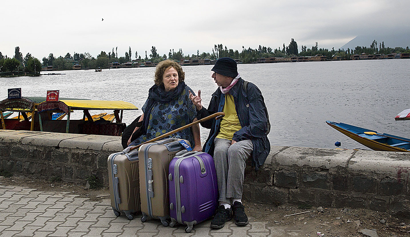 An Italian couple wait for their taxi as they prepare to leave Srinagar on Saturday.