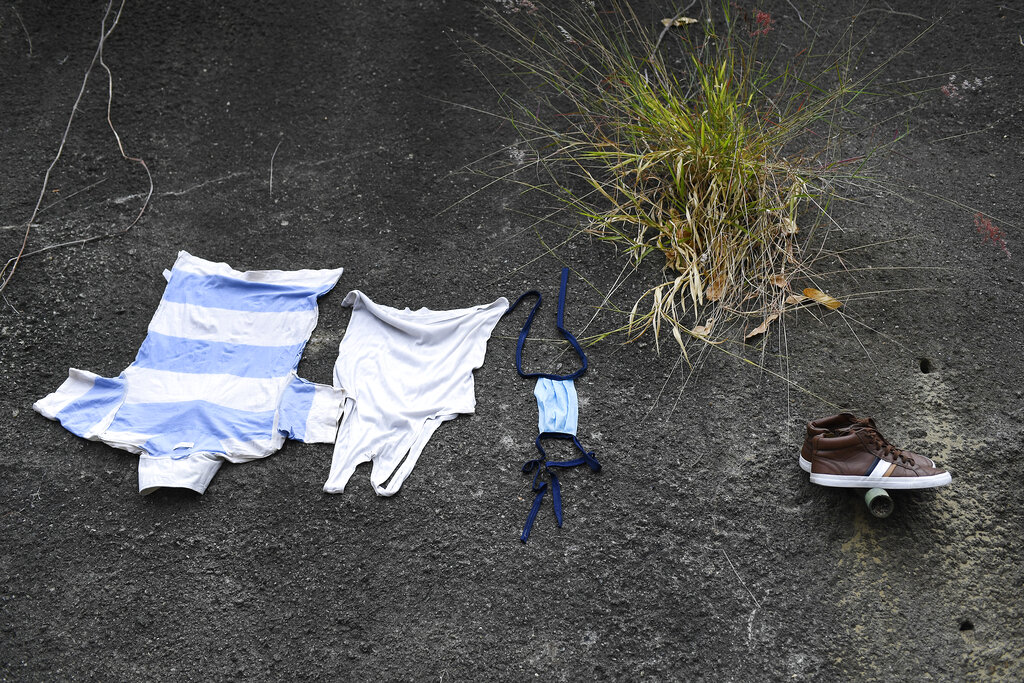 Clothes and a protective face mask are laid out to dry after being washed with runoff water at the base of the Avila mountain in Caracas, Venezuela, Saturday, April 4, 2020.