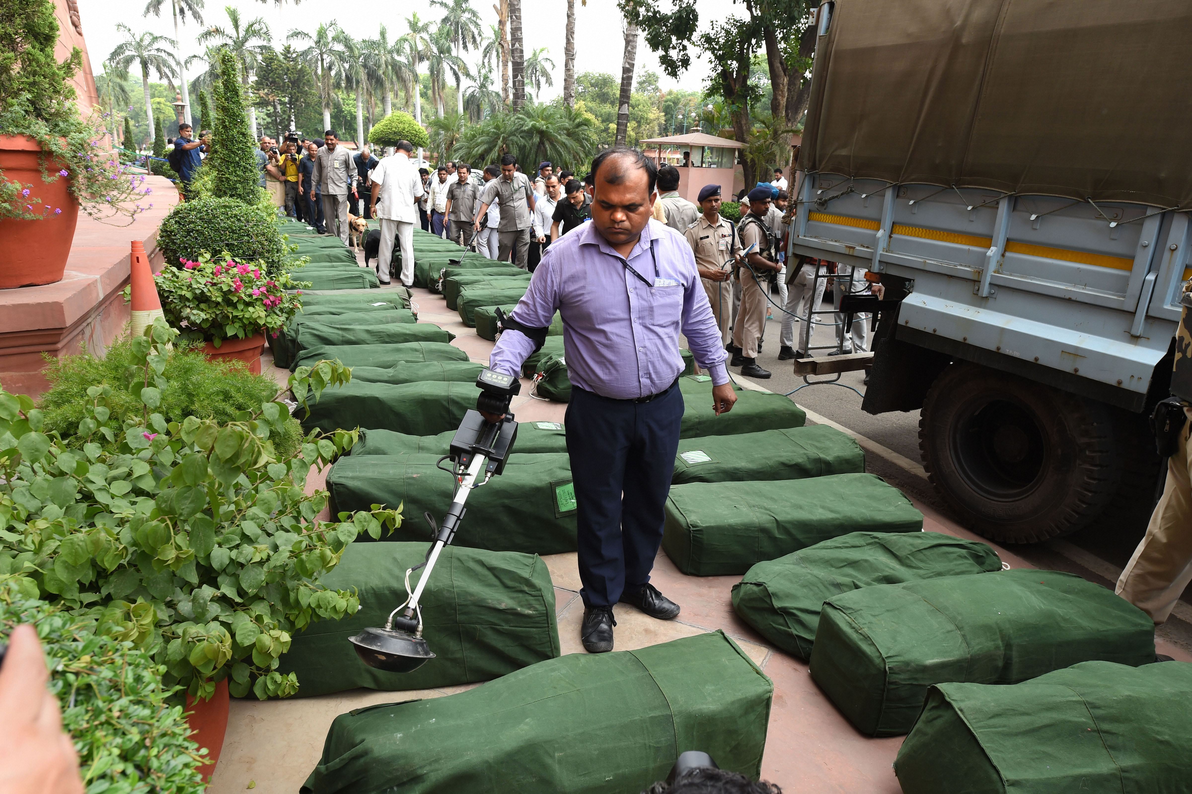 A security official checks sacks containing copies of Union Budget outside Parliament on July 5.