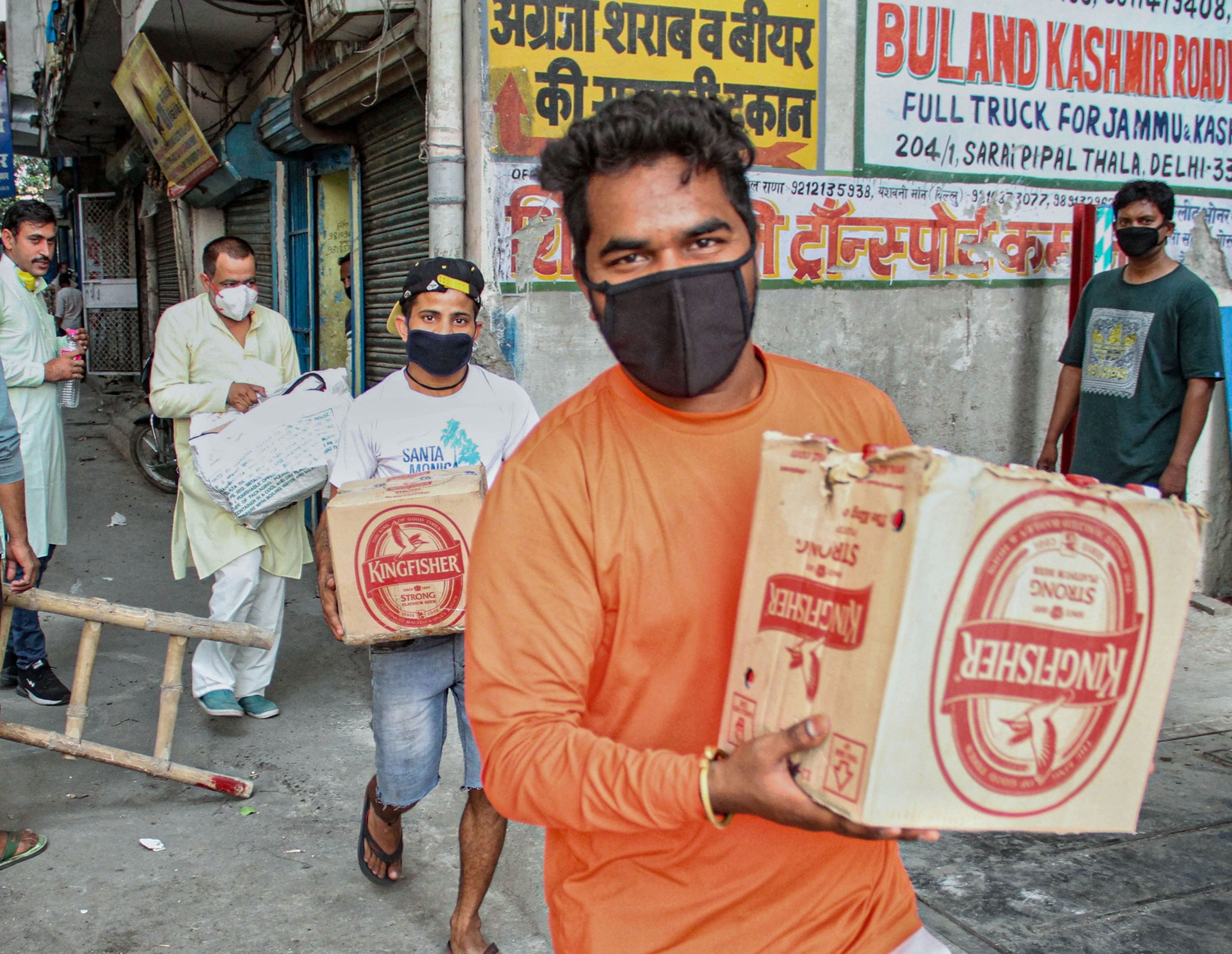 People leave after purchasing liquor from a wine shop during the third phase of the Covid-19 lockdown, near Azadpur Sabzi Mandi in New Delhi, Friday, May 8, 2020. 