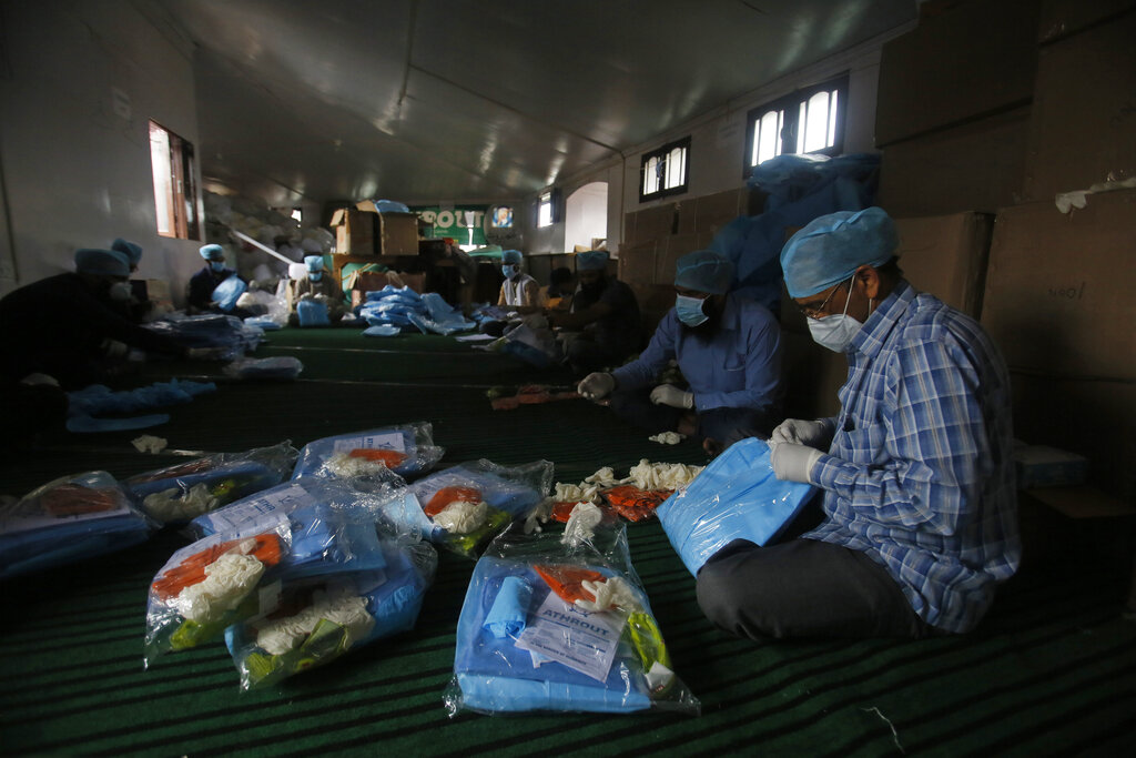 Volunteers of Athrout, a voluntary organization pack Covid-19 protective kit before distributing it to medical workers in Srinagar, Jammu and Kashmir, Monday, May 4, 2020.
