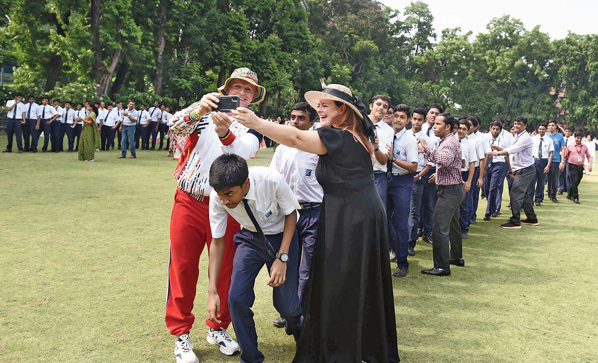 Roald Bradstock and Dianne De Navacelle take selfie with students.