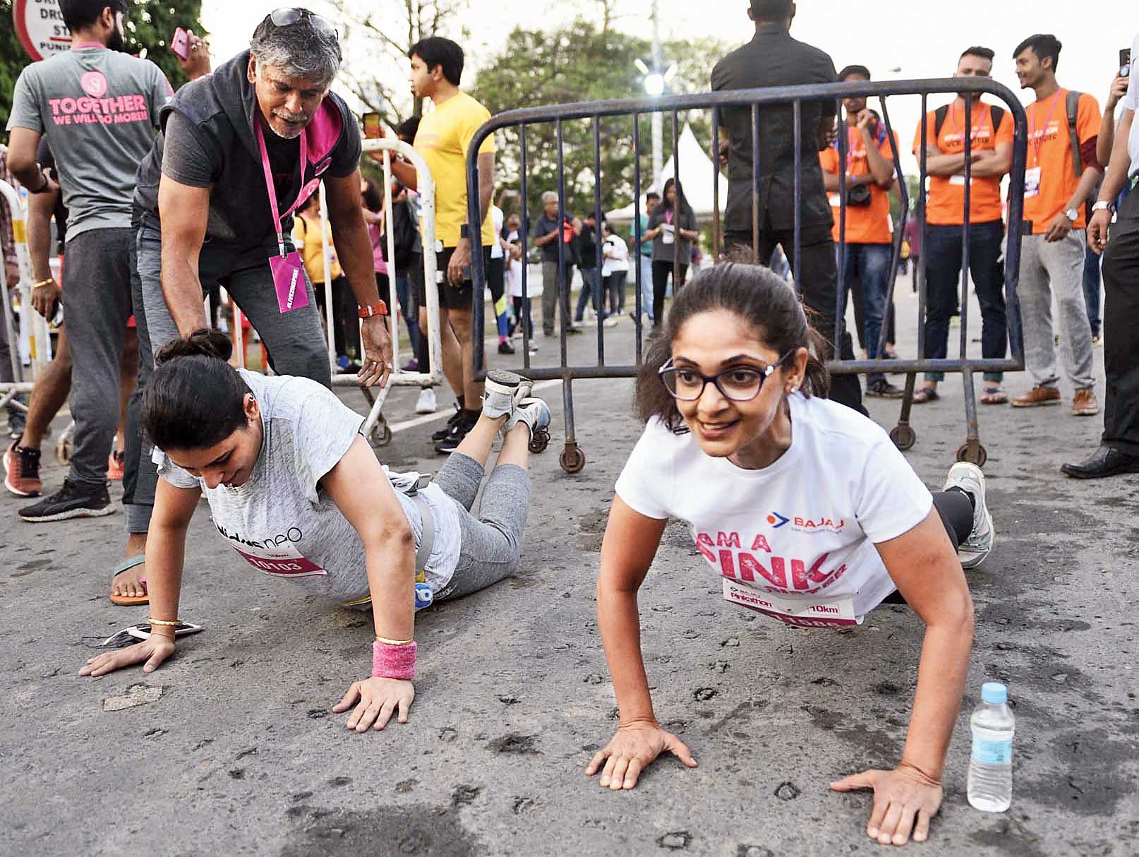 Two participants compete against each other with 20 push-ups for a selfie with Milind Soman, the co-founder of Pinkathon