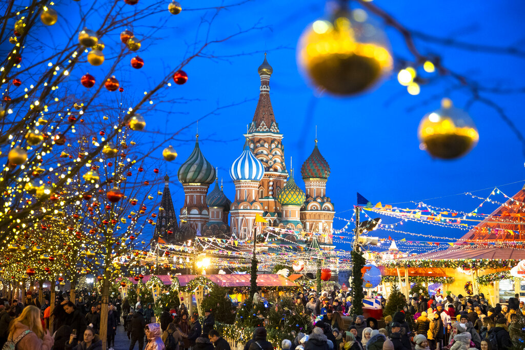 People walk in Red Square decorated for Christmas and New Year celebrations, with the St. Basil's Cathedral in the background in Moscow, Russia.