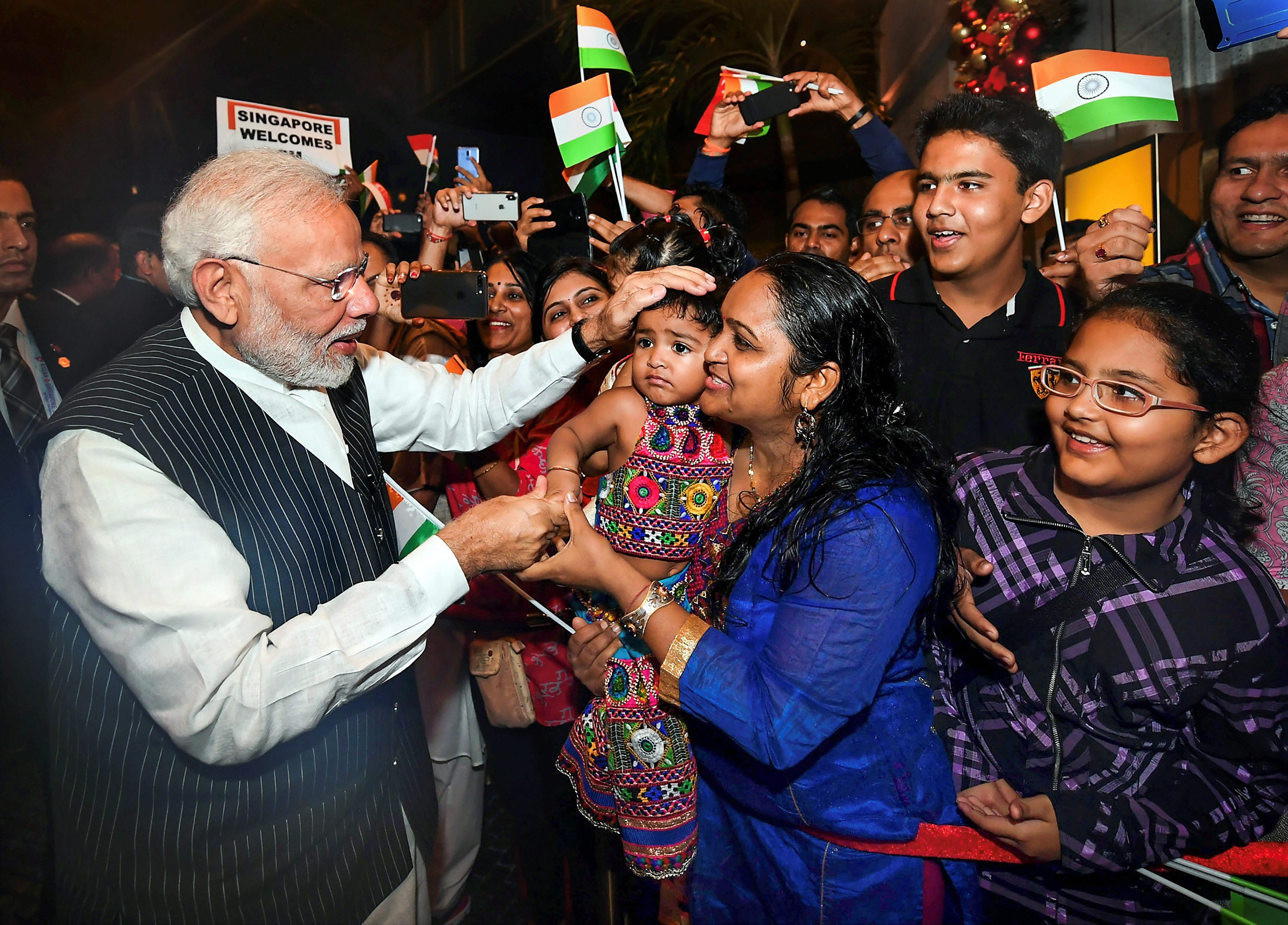 Narendra Modi is greeted by Indian residents after his arrival in Singapore.