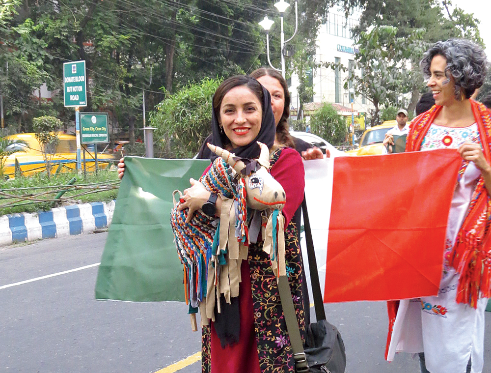 A participant from Iran takes part in the procession with a puppet