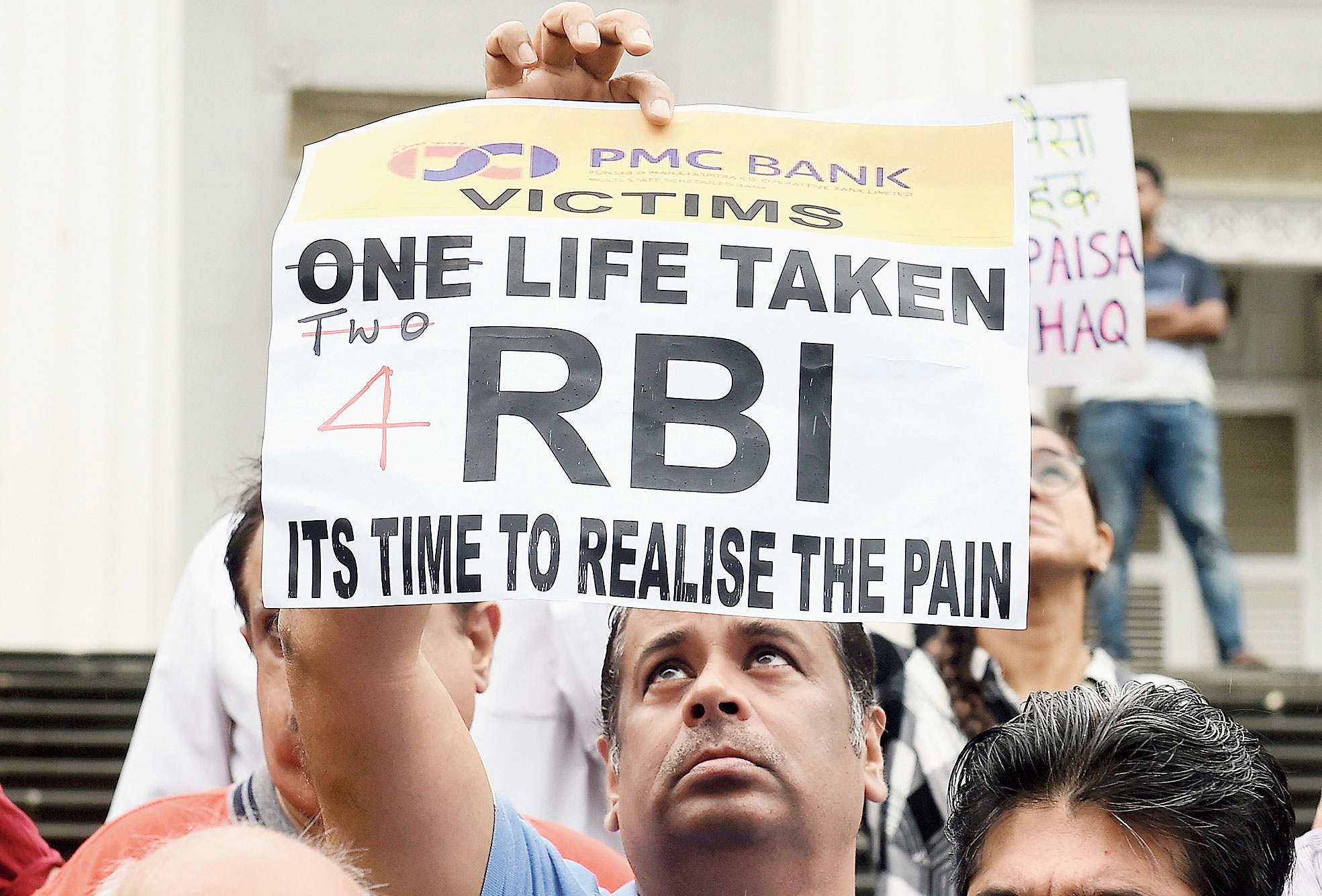 Depositors of PMC display placards during the protest outside the RBI headquarters in Mumbai on Saturday. 