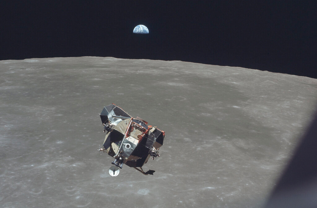 The Apollo 11 Lunar Module ascent stage. The Earth rises above the lunar horizon