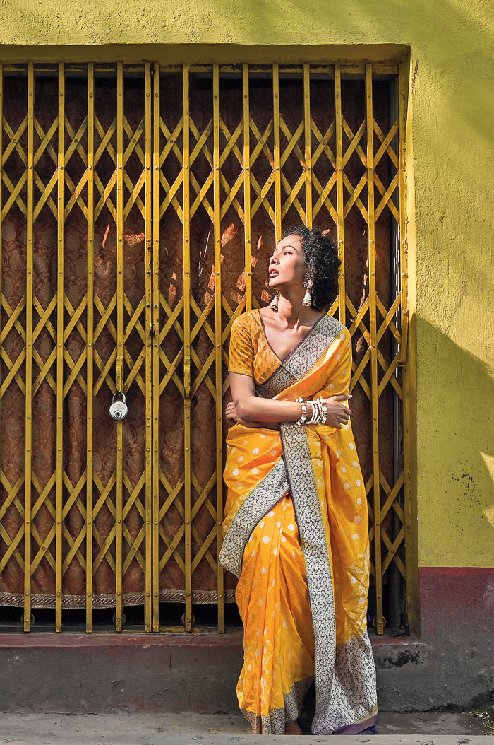 Ushoshi looked straight out of a quaint painting in this marigold yellow tanchoi. A dark purple border with traditional badla work and the pallu has jangla motifs. The sari is paired with a matching blouse and a pair of pearl jhumkas. “It is a completely traditional look and that little bit of oomph comes from the messy braid,” said Shreevatsa.