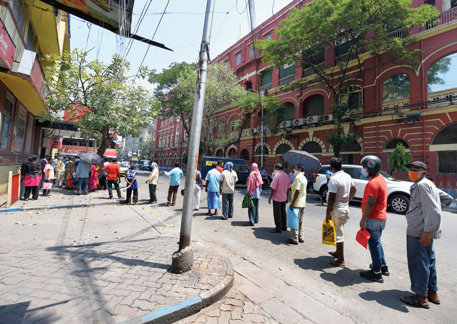 Calcutta Municipal Corporation employees queue up to draw their salaries from a bank opposite the civic headquarters on SN Banerjee Road