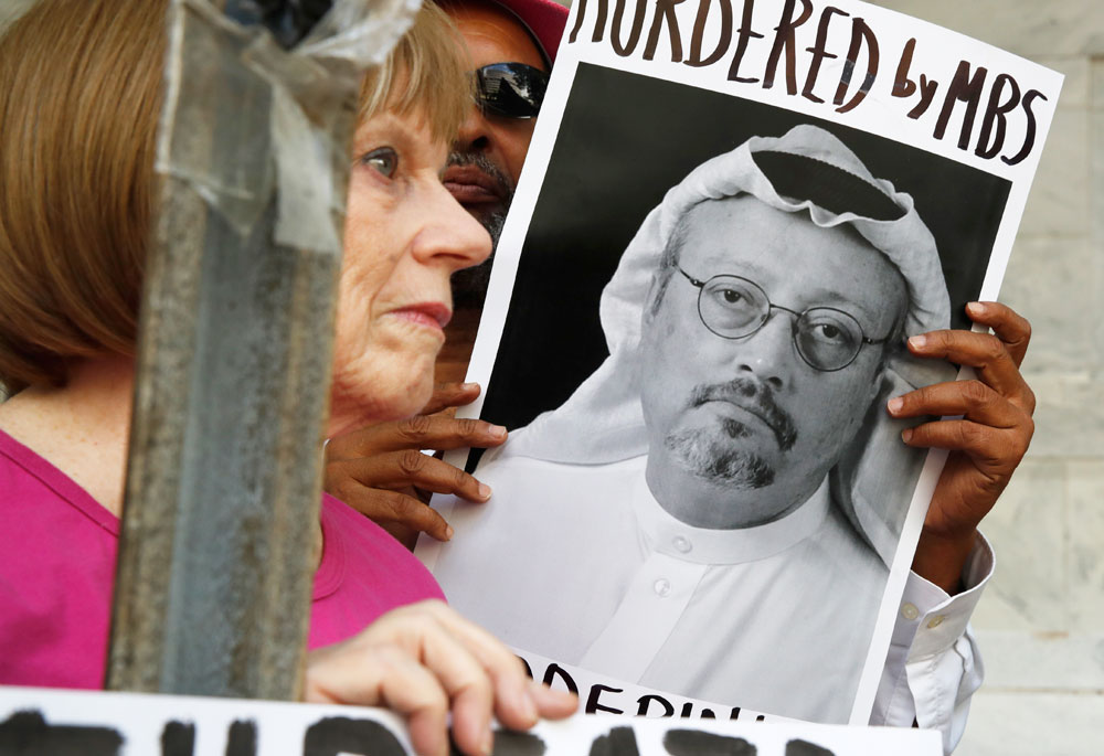People hold signs during a protest at the Embassy of Saudi Arabia about the disappearance of Saudi journalist Jamal Khashoggi on Wednesday, Oct. in Washington. 
