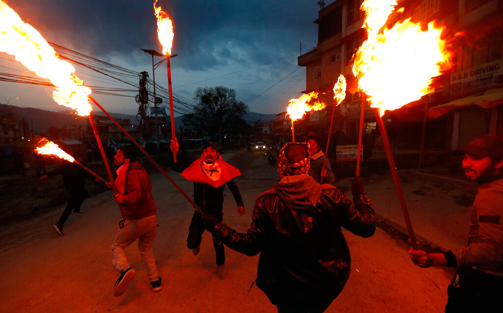 Students affiliated with Nepal Student Union light torches during a protest amid lockdown in Kathmandu, Nepal, Monday, May 11, 2020. The protest was held against the Indian government Friday inaugurating a new road through a disputed territory between India and Nepal.